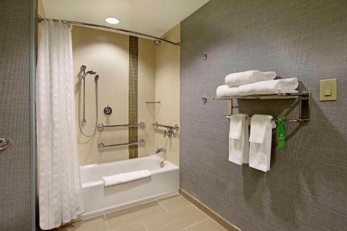 a bathroom with a tub and a shower with towels at Hyatt Place Houston/Katy in Katy