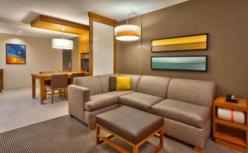 a living room with a couch and a dining room at Hyatt Place Salt Lake City Farmington Station Park in Farmington