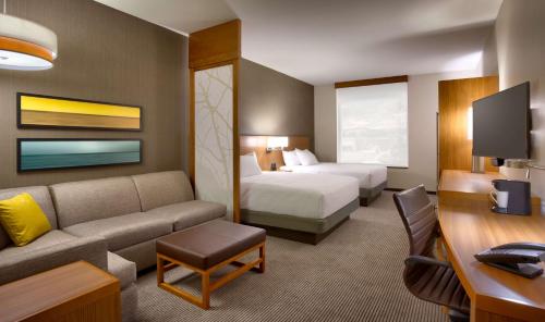 a hotel room with a bed and a couch at Hyatt Place Salt Lake City Farmington Station Park in Farmington