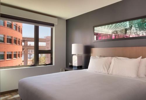 a bedroom with a white bed and two windows at Hyatt House Portland / Downtown in Portland