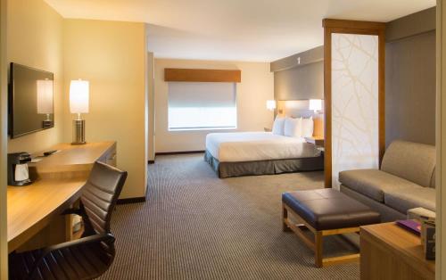 Hyatt Place Orlando/Lake Buena Vista في أورلاندو: غرفة في الفندق مع سرير ومكتب