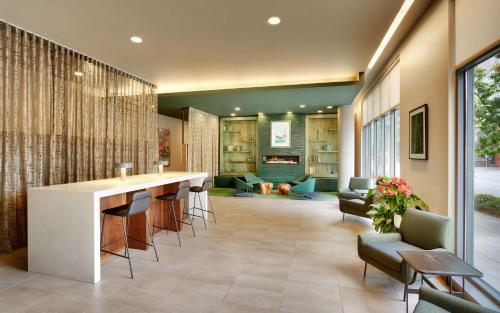 a lobby with a bar and chairs and a living room at Hyatt House Portland / Downtown in Portland