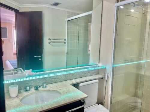 a bathroom with a sink and a glass shower at Hotel America International Jardins in Sao Paulo