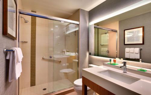 Hyatt Place Emeryville/San Francisco Bay Area في إيميريفيل: حمام مع دش ومغسلة ومرحاض
