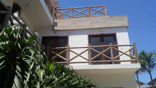 a building with a balcony with windows and plants at Pousada Solarium in Canoa Quebrada