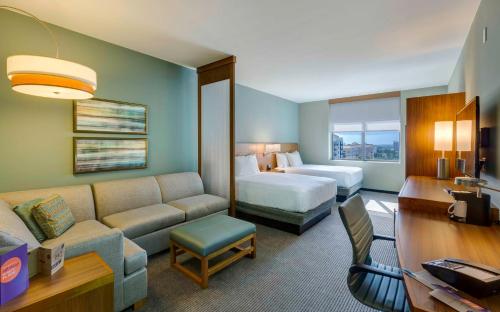Hyatt Place Boca Raton في بوكا راتون: غرفة فندقية بسرير واريكة وسرير وغرفة