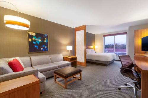 een hotelkamer met een bank en een bed bij Hyatt Place Blacksburg/University in Blacksburg