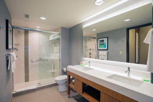 ein Bad mit einem Waschbecken, einer Dusche und einem WC in der Unterkunft Hyatt Place Cincinnati/Sharonville Convention Center in Sharonville