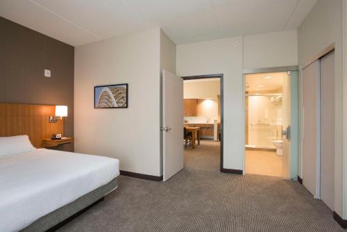 a hotel room with a bed and a bathroom at Hyatt Place Cincinnati/Sharonville Convention Center in Sharonville