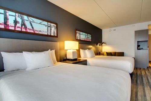 two beds in a hotel room with white sheets at Hyatt House Chicago/Evanston in Evanston