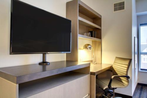 a desk with a tv and a chair in a room at Hyatt House Chicago/Evanston in Evanston