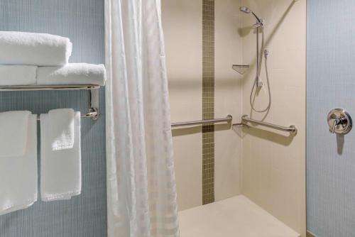 a bathroom with a shower and a toilet with towels at Hyatt Place Dallas/Allen in Allen