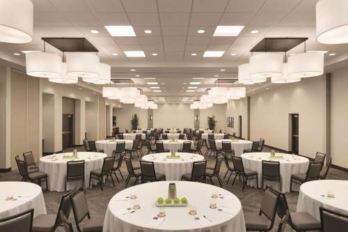 a banquet hall with white tables and chairs and chandeliers at Hyatt Place Chicago O'Hare Airport in Rosemont