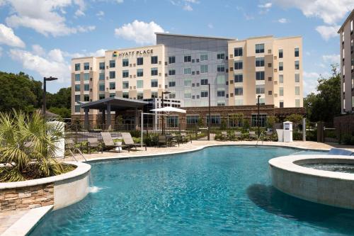 a hotel with a swimming pool in front of a building at Hyatt Place Biloxi in Biloxi