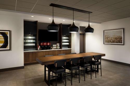 a dining room with a large wooden table and black chairs at Hyatt Place Biloxi in Biloxi