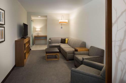 a living room with two couches and a tv at Hyatt Place Biloxi in Biloxi