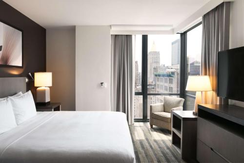 a hotel room with a bed and a large window at Hyatt House New York/Chelsea in New York