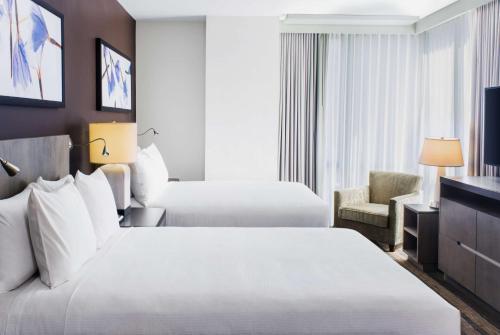 a hotel room with two beds and a television at Hyatt House New York/Chelsea in New York