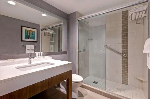 a bathroom with a toilet and a sink and a shower at Hyatt Place Bloomington / Normal in Bloomington