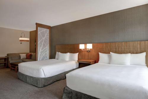 a hotel room with two beds and a chair at Hyatt Place Bloomington / Normal in Bloomington