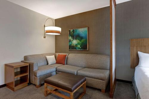 a hotel room with a couch and a bed at Hyatt Place Bloomington / Normal in Bloomington