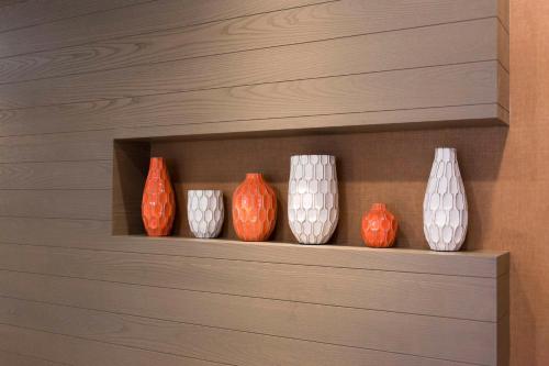 a row of orange and white vases on a shelf at Hyatt House Charleston - Historic District in Charleston