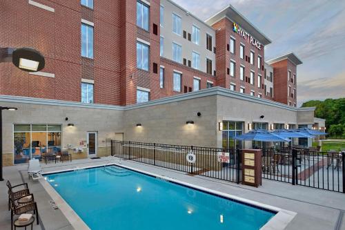 une piscine en face d'un hôtel avec un bâtiment dans l'établissement Hyatt Place Chapel Hill, à Chapel Hill