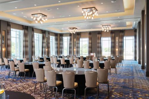 a conference room with tables and chairs and windows at Hyatt House Charleston - Historic District in Charleston