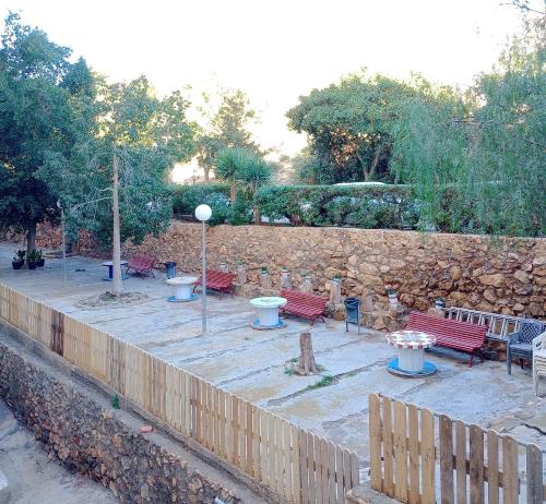 un jardín con bancos y una pared de piedra. en El Espejo del Mar en Almería
