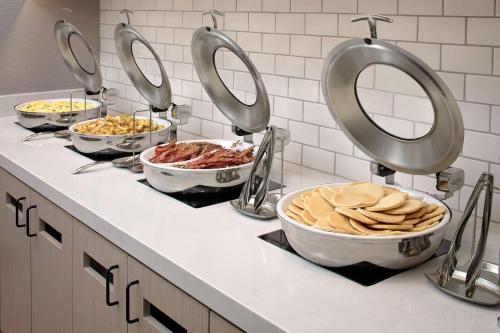 a kitchen counter with four bowls of food on it at Hyatt House Irvine/John Wayne Airport in Irvine