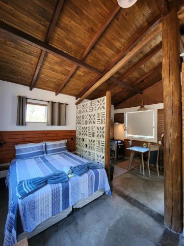 1 dormitorio con 1 cama en el techo de madera en Refúgio Tao Cerrado Chalé Brisa Da mata, en Alto Paraíso de Goiás