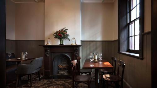 a dining room with two tables and a fireplace at Hyatt Regency Sydney in Sydney
