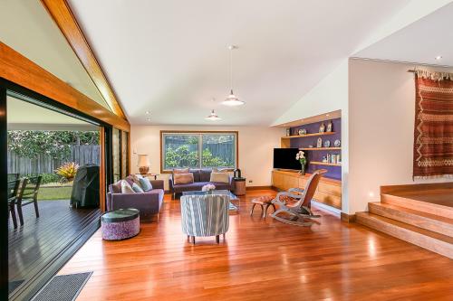 ein Wohnzimmer mit einem Sofa und einem Tisch in der Unterkunft Cabarita Beach Oasis - 3BR Beach House by uHoliday in Cabarita Beach