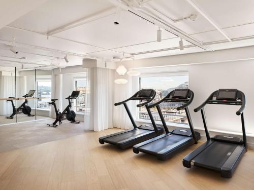 a gym with treadmills and ellipticals in a building at Hyatt Regency Sydney in Sydney