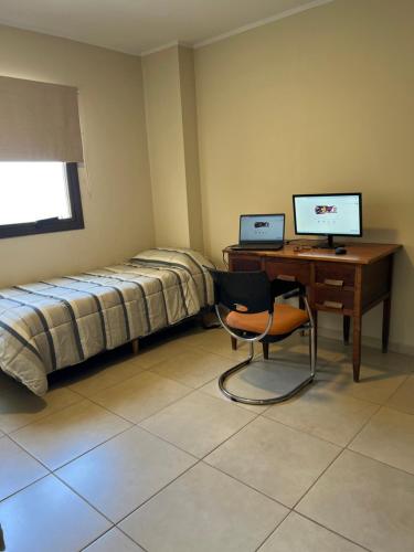um quarto com uma secretária, uma cama e um computador em Dpto 7-UNNE em Resistência