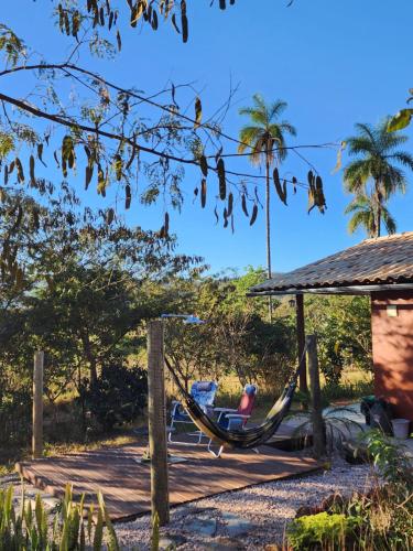 a person in a hammock on a deck at Refúgio no meio da natureza - Chalé Brisa Da mata in Alto Paraíso de Goiás