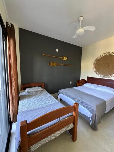 a bedroom with two beds and a ceiling fan at Apartamento na praia Garopaba San Pietro Sc loft 101 in Garopaba
