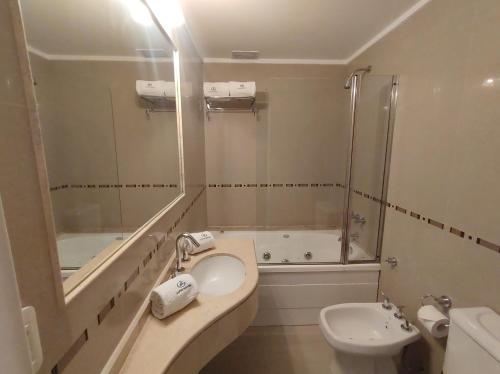 a bathroom with a sink and a toilet and a tub at Goya Hotel in Buenos Aires