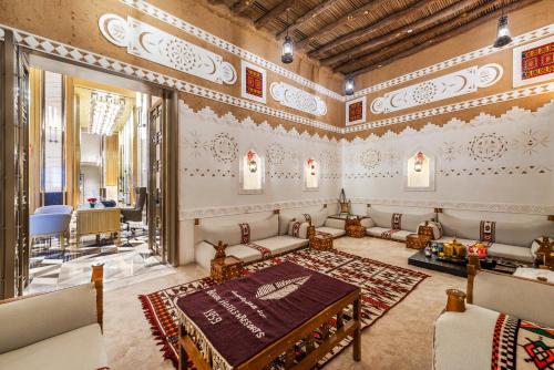 Habitación con cama, sofá y mesa. en Narcissus The Royal Hotel en Riad