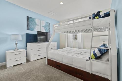 a bedroom with a bunk bed and a television at Lovely Condos 18 Minutes away from Disney! in Kissimmee