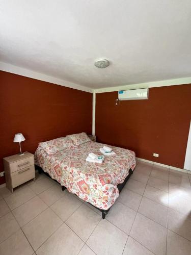 a small bedroom with a bed and a night stand at Hotel Aimara in Mina Clavero