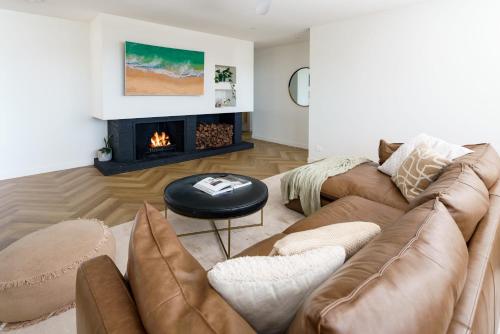 a living room with a couch and a fireplace at Villa Parkana - Beachside Buddina in Buddina