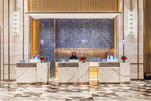 a rendering of a lobby with three people at reception desks at Narcissus The Royal Hotel in Riyadh