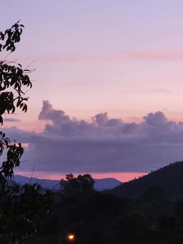 a sunset with a view of the mountains at Refúgio no meio da natureza - Chalé Brisa Da mata in Alto Paraíso de Goiás