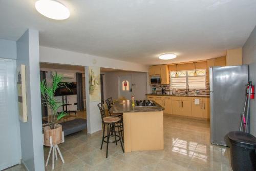 a kitchen with a stainless steel refrigerator and a table at EcoMar Rentals Casa:, Naturaleza, Piscina & Playa in Cabo Rojo