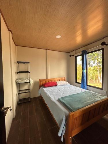 1 dormitorio con 1 cama en una habitación con ventana en Cabaña La Chavela 