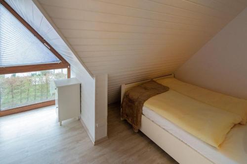 - un petit lit dans une chambre avec fenêtre dans l'établissement Fewo-Gyde-3-Haustiere-erlaubt-WLAN-kostenlos, à Norddeich