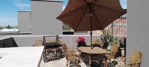 a table and chairs with an umbrella on a patio at BELLAS VILLAS, VILLA AMOR HERMOSA CASA a UN ACCECIBLE PRECIO in San Miguel de Allende