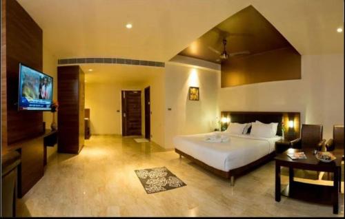 NESTLAYROOMS RAMNAD في راماناثابورام: غرفة نوم بسرير وتلفزيون في غرفة