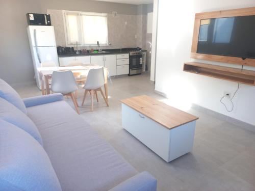 a living room with a white couch and a table at Villa las Marias in San Carlos de Bariloche